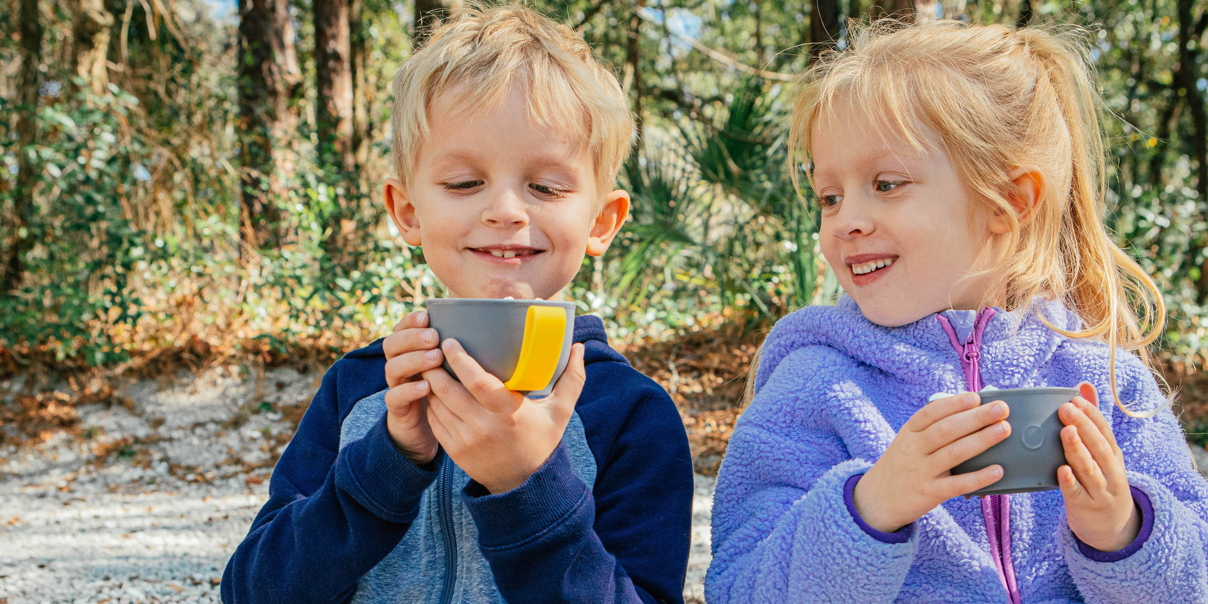 Girl and boy are drinking cocoa from thermos